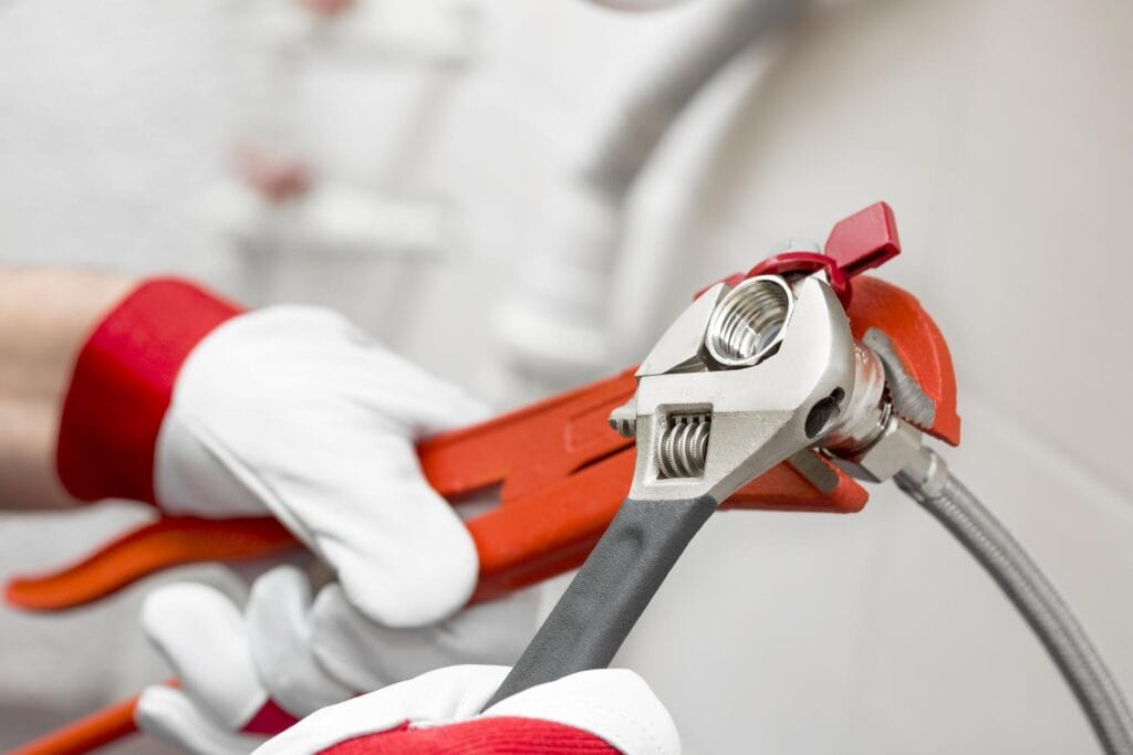 Plumber holding pipe wrenches for an emergency repair in Calhoun
