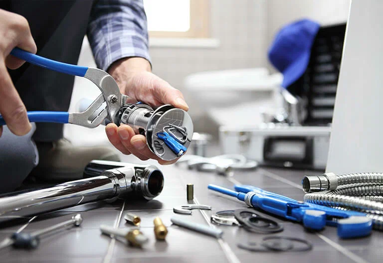 Technician repairing a plumbing fixture with professional tools in Calhoun