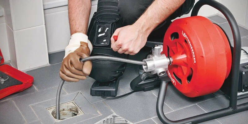Plumber using a drain-cleaning machine in Calhoun