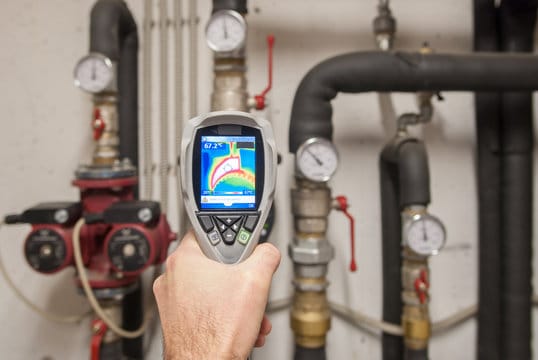 Plumber using a thermal imaging camera to inspect pipes in Calhoun