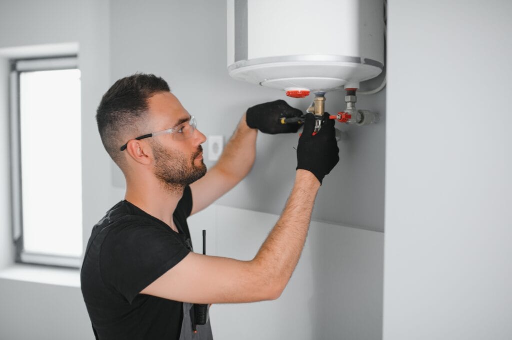Technician performing water heater maintenance in Calhoun
