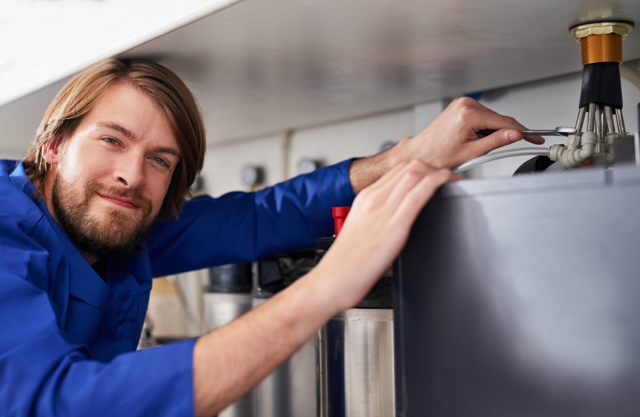 Technician servicing a residential water heater tank in Calhoun
